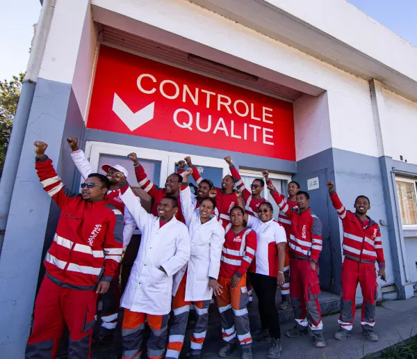 Les membres de l'équipe Labo levant les mains devant le laboratoire